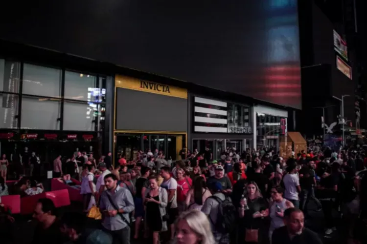 People walk along a dark street near Times Square area USA