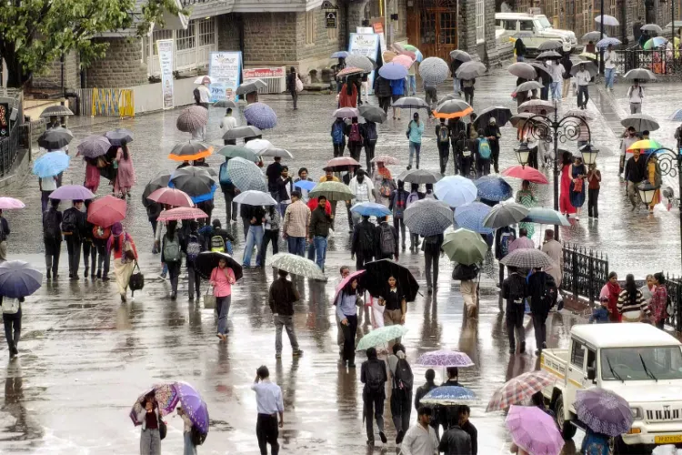People cover themselves with umbrellas as they walk amid rainfall 