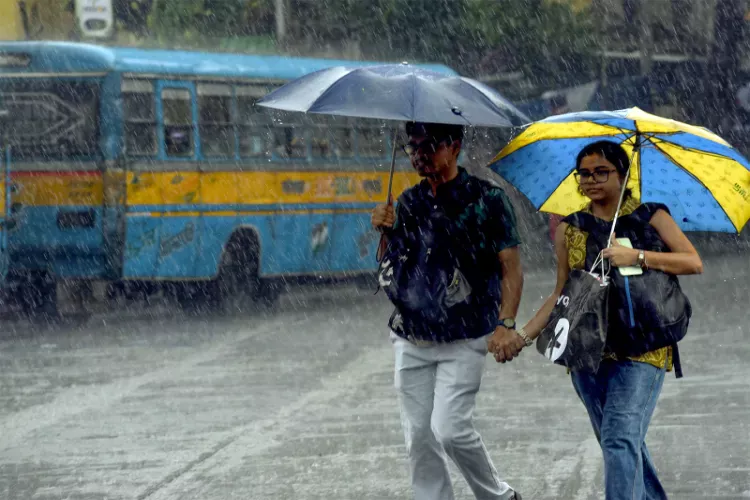 People walk under umbrellas amid heavy monsoon showers